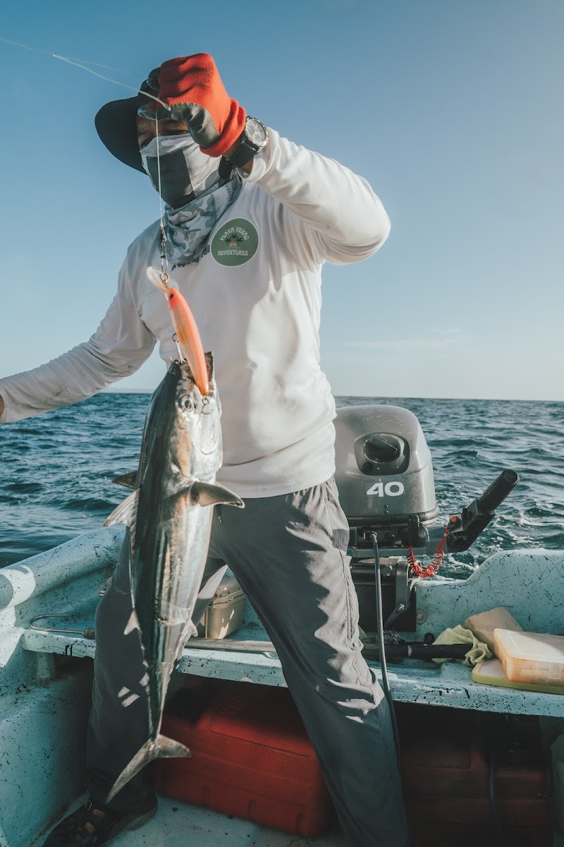 A Playa Venao Adventures guide in branded gear with a fresh catch on the boat