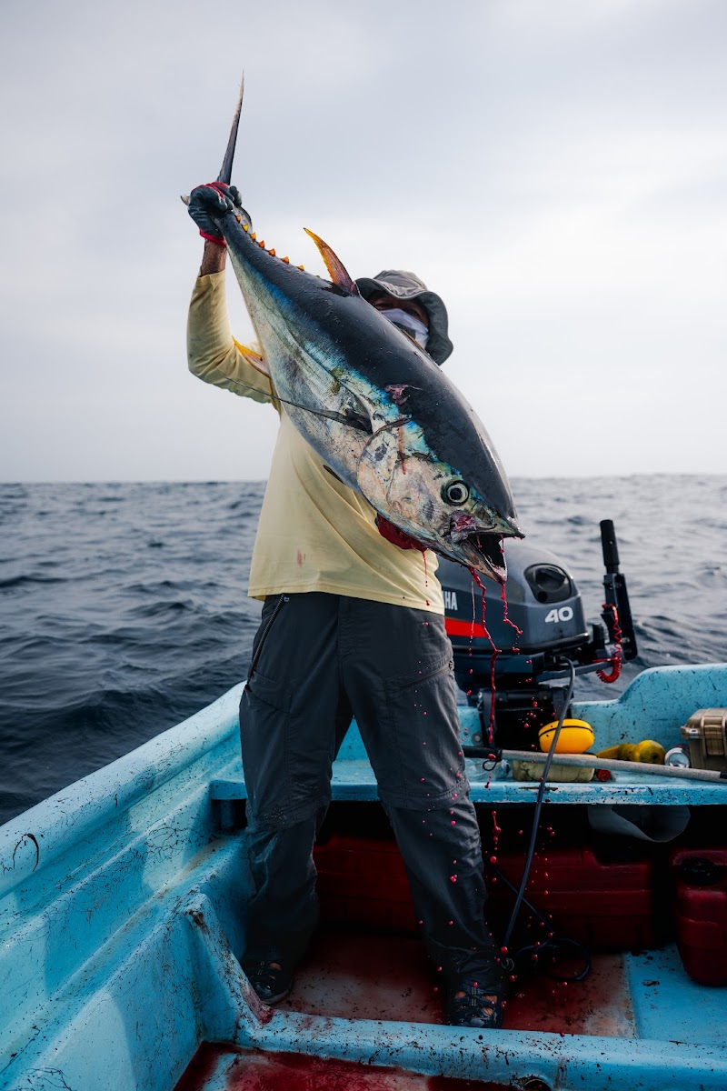 Angler holding up a large yellowfin tuna on the boat